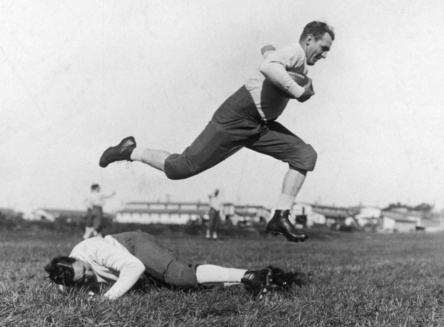 "Red" Grange, leaping over coach Ralph Scott in practice, 1925.