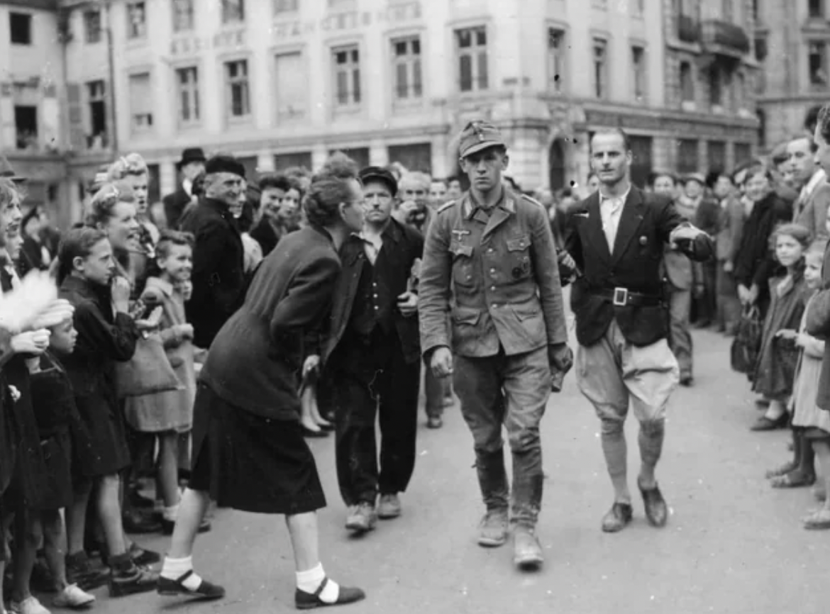 A German soldier caught by the French Resistance is led through the streets, St Mihiel, France, Sept 1944.