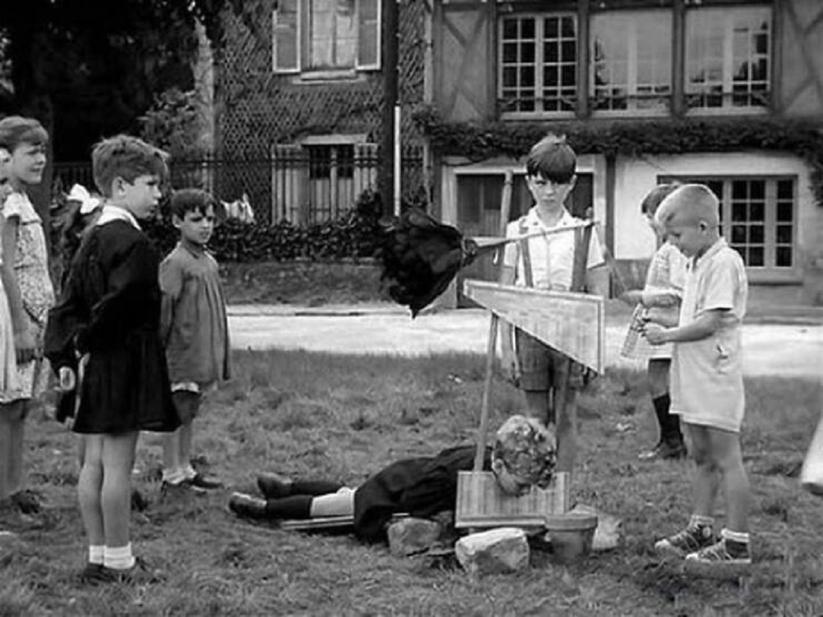 Children in France playing with a toy guillotine, 1959.