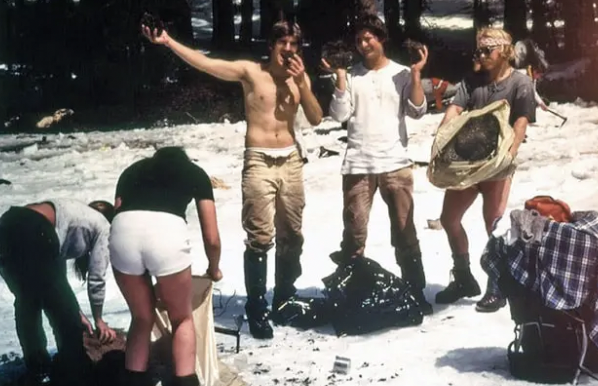 A group of hippies recovering bags of marijuana from the frozen Lower Merced Pass Lake in Yosemite National Park, which fell from a crashed smuggler's plane; January 1977.