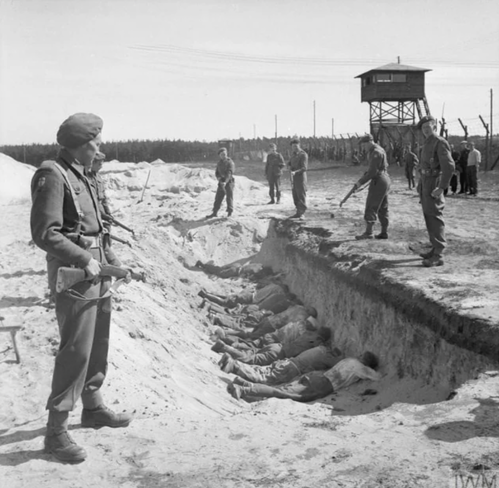 British soldiers force captured SS guards to take their break lying face down in an empty mass grave, 1945. 