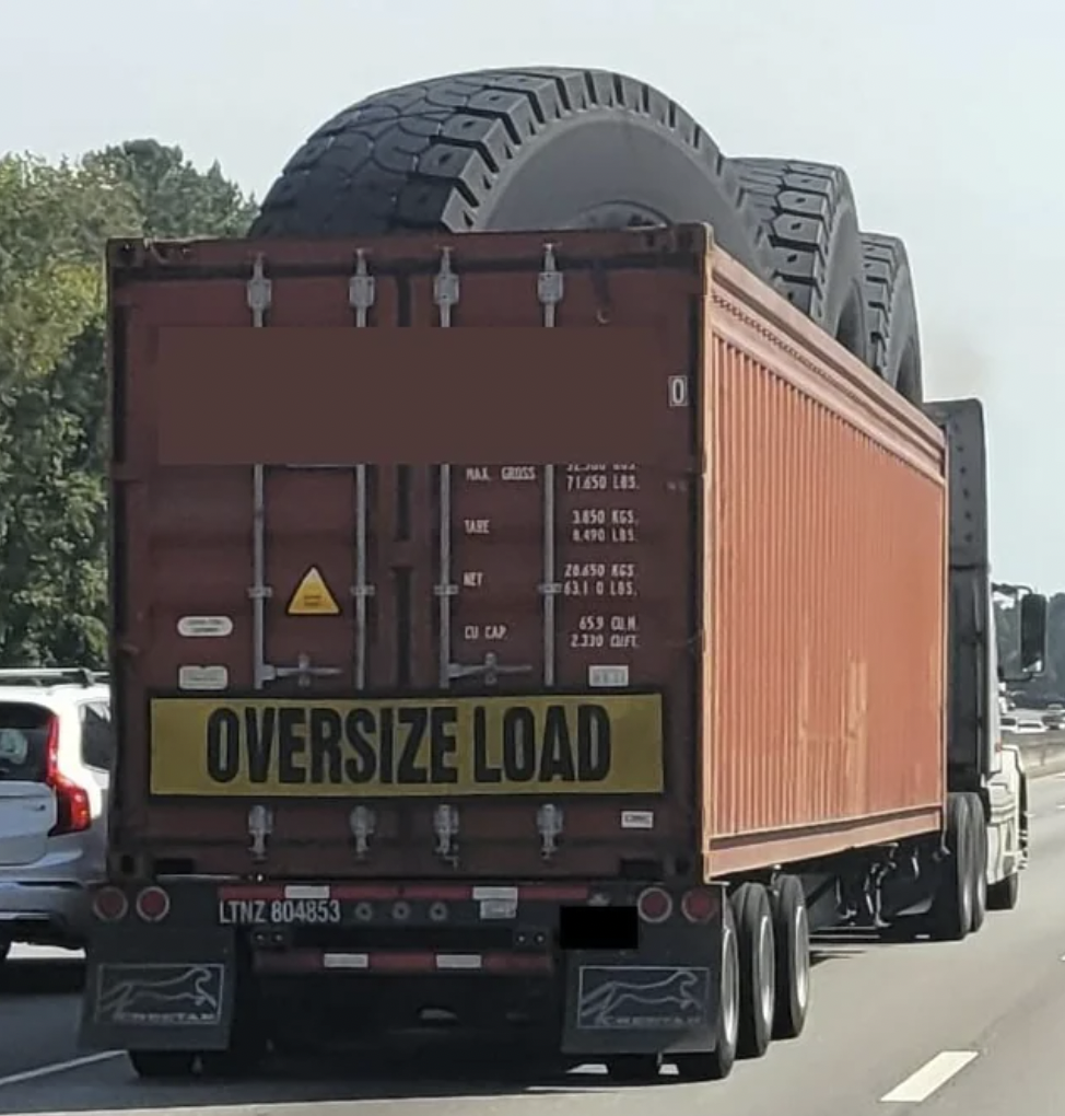 Truck hauling extremely large tires.