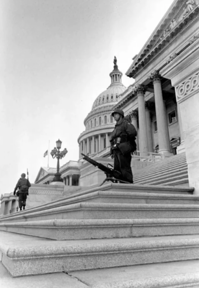 Soldier stands besides his M60 machine gun, which is mounted on the steps of the U.S. Capitol to deter rioters from entering the building during the Martin Luther King Jr. assassination riots in Washington D.C. April 1968.