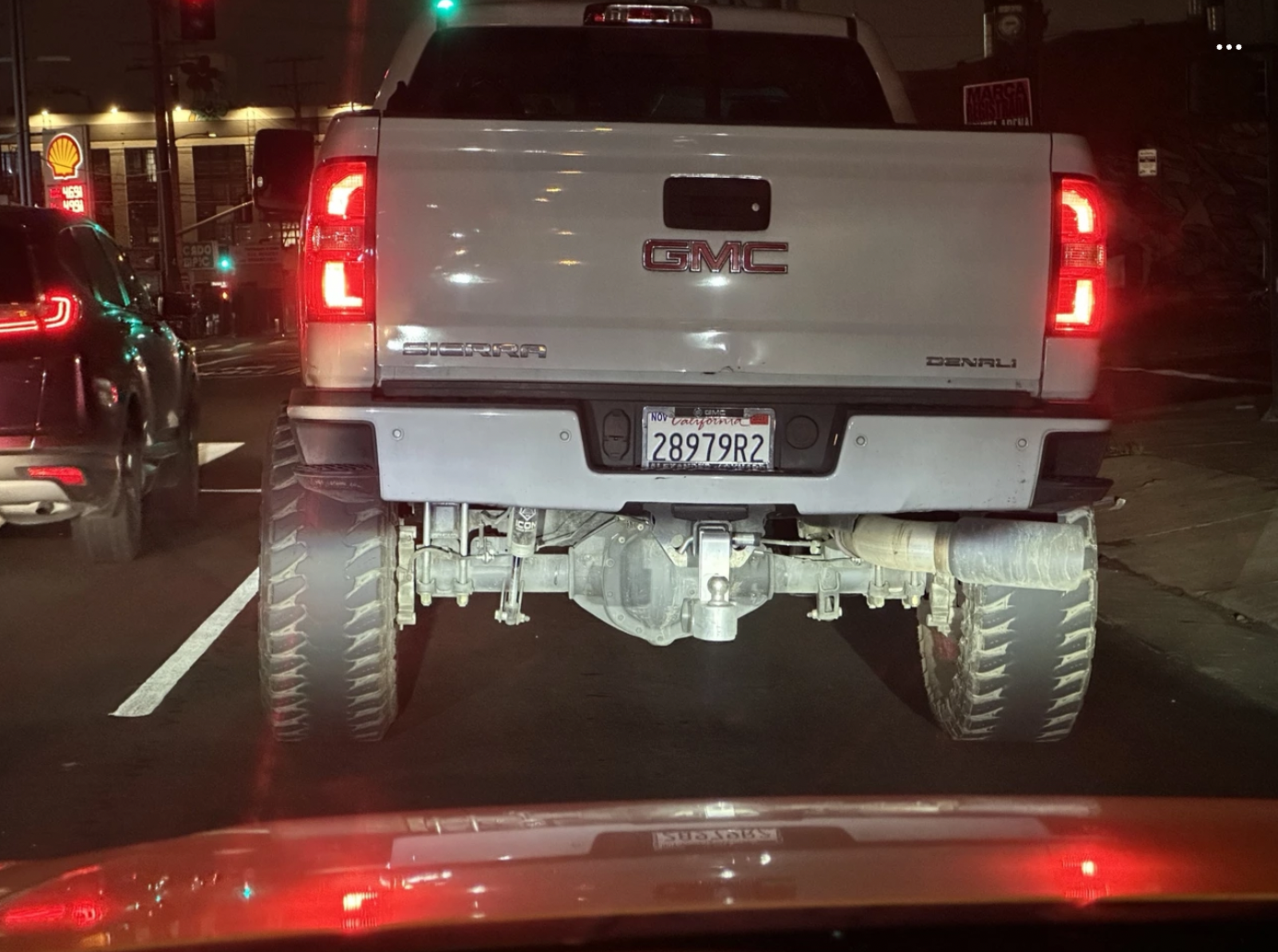 “Lifted truck with bald tires speeding and swerving through lanes.”
