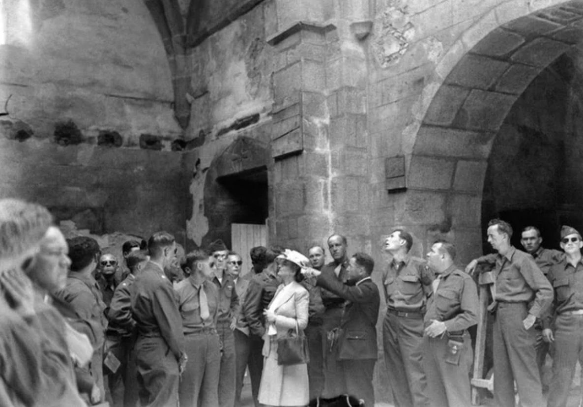 French civilians and servicemen inspecting the church of a French village, where women and children were shut in and burned, 1945.