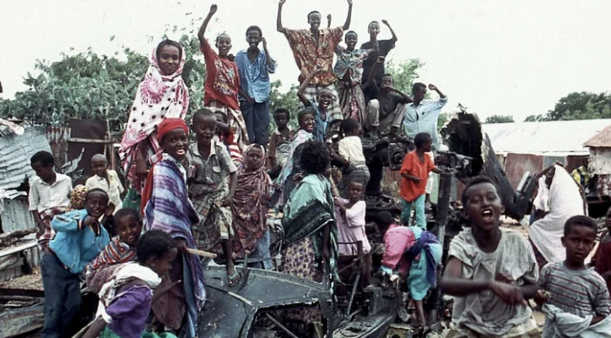 A group of young Somalis chant anti American slogans while sitting atop the burned out hulk of a U.S. Black Hawk helicopter. On October 3rd 1993, an American attack against a warlord in Mogadishu failed. 18 US soldiers and over 350 Somalis, including civilians, died.