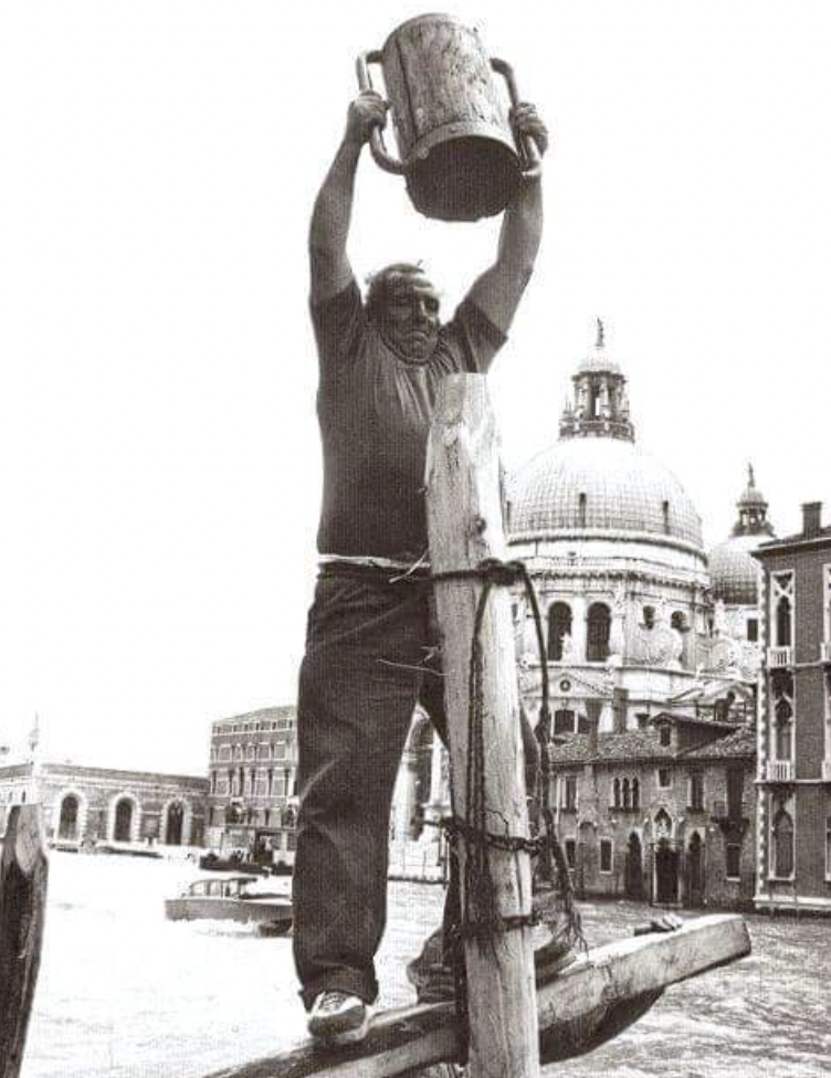 Grand Canal, Venice, Italy. Circa 1970. Planting a pole in the water to tie the boat on it.