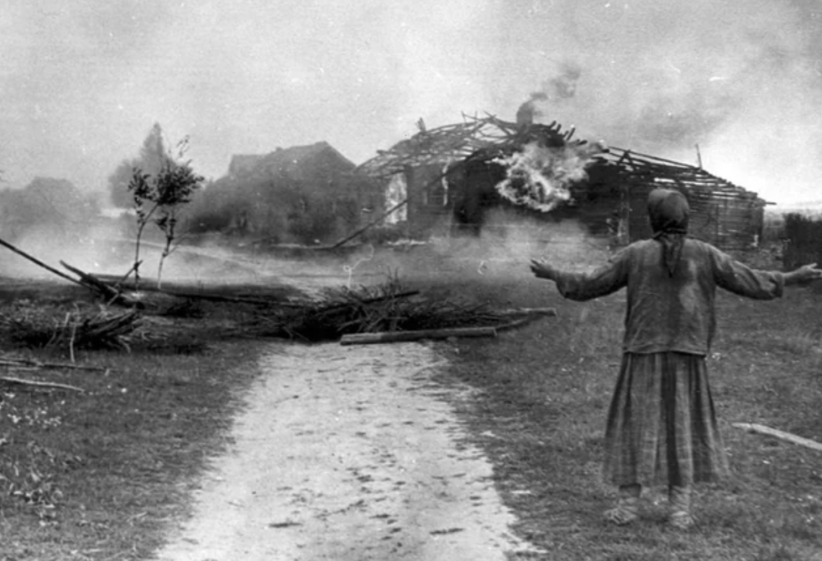 A Russian woman watches a building burn, sometime in 1942.