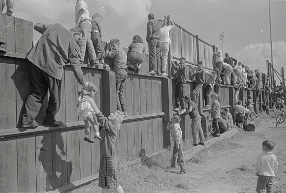 October, 1962: Fans climb the fence to view the World Series at Candlestick Park in San Francisco, California.