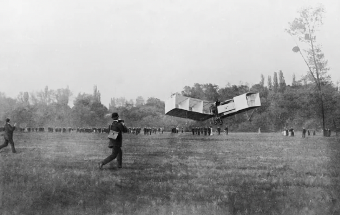 Brazilian aeronaut Alberto Santos-Dumont flies the fixed-wing 14-bis 'Oiseau de Proie II' in the first heavier-than-air flight in Europe. The plane lifted off and flew for 60 meters without taking advantage of headwinds, ramps, catapults, slopes, or other devices. Paris, 1906.