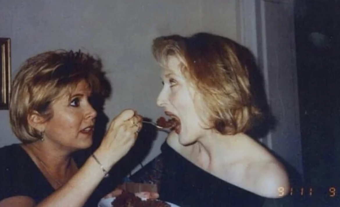 Carrie Fisher feeding Meryl Streep a piece of chocolate cake, 1991.