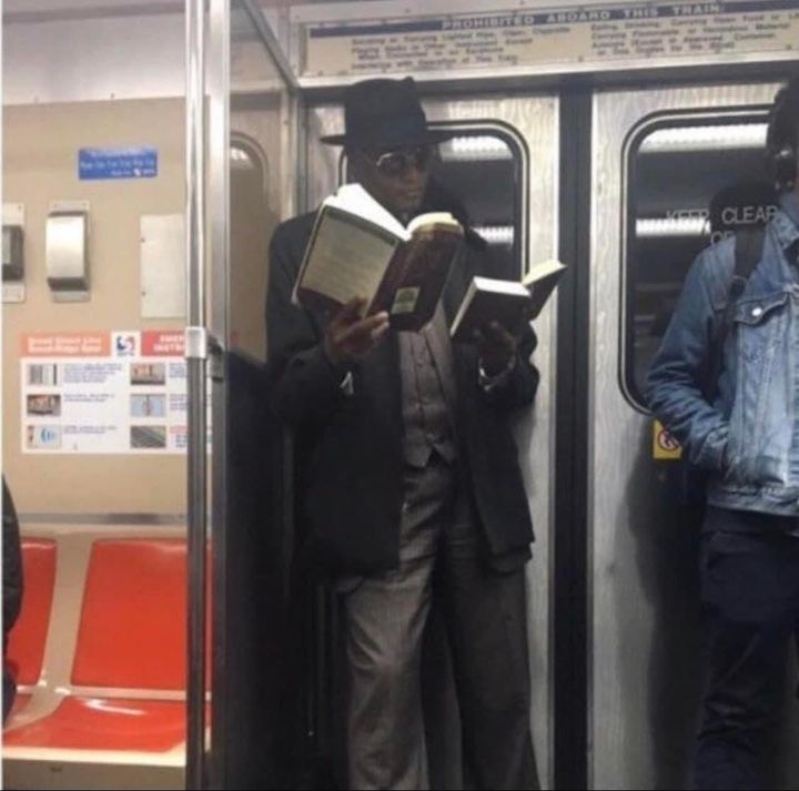 guy reading two books on subway - Abdaro Train Keep Clear
