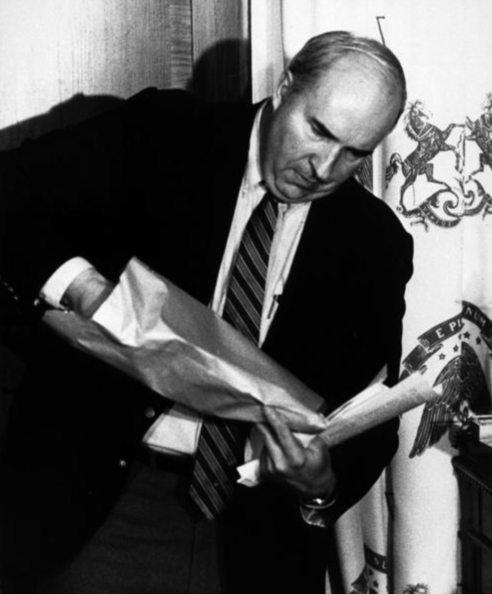 Politician Budd Dwyer opening an envelope. He was holding a televised press conference about a scandal he was being accused of when the envelope was delivered to him during the press conference. He'd continue by opening the envelope, revealing a handgun that he promptly put in his mouth, and used to kill  himself live on national television. This is one of the primary reasons many "live" news reports are preempted by a few minutes.