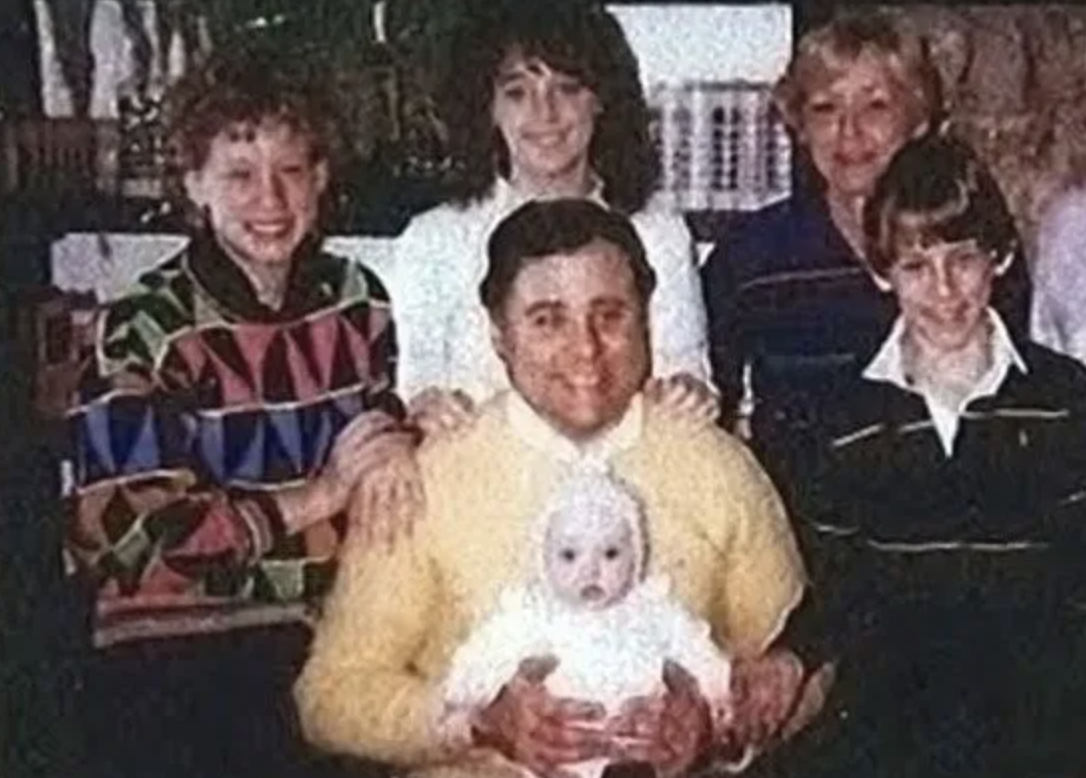 John Edwards Robinson, (yellow sweater), is holding baby Tiffany, whose mother he murdered the day before. He gave baby Tiffany to his brother, saying she was adopted. His brother, along with Tiffany, didn’t find out the truth for 15 years.