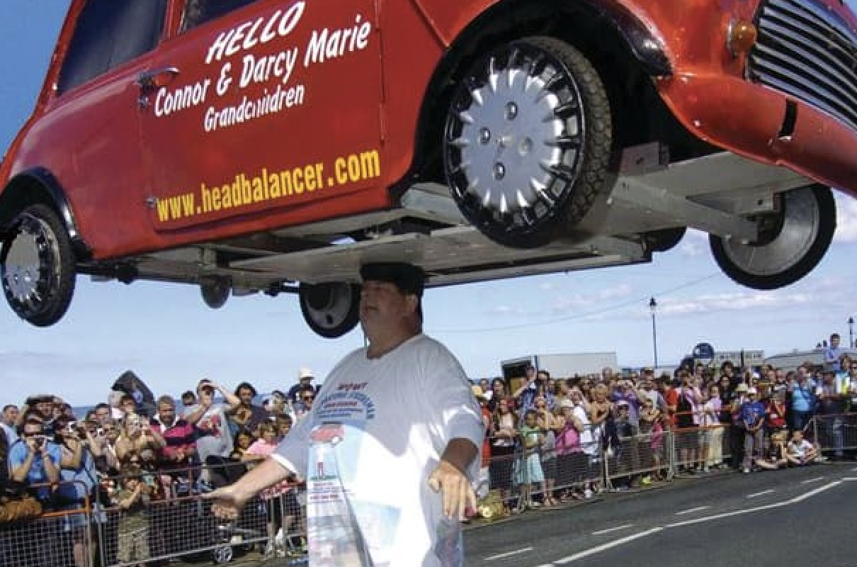 British man John Evans balanced a 352-pound car on his head for 33 seconds.