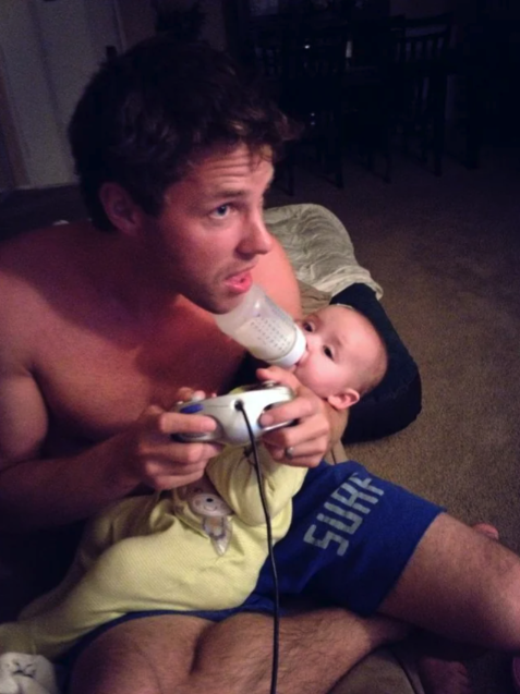 holding baby while playing video games - Surf