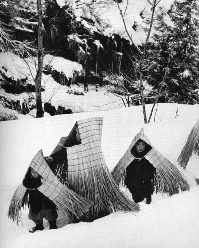 Children with straw capes for protection from the weather. Japan,