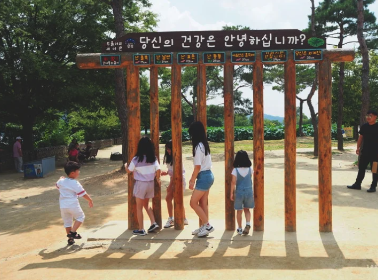Children checking how fat they are in Korea using a government installed width gate.