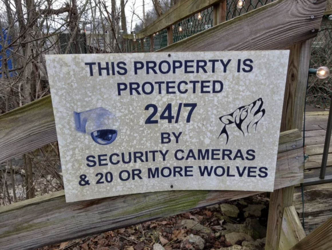 Sign - This Property Is Protected 247 By Security Cameras & 20 Or More Wolves