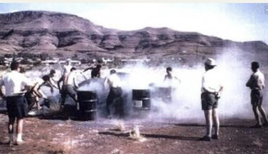 Workers shovel raw blue asbestos tailing into drums at an asbestos shoveling competition at Wittenoom, Western Australia. 1962.