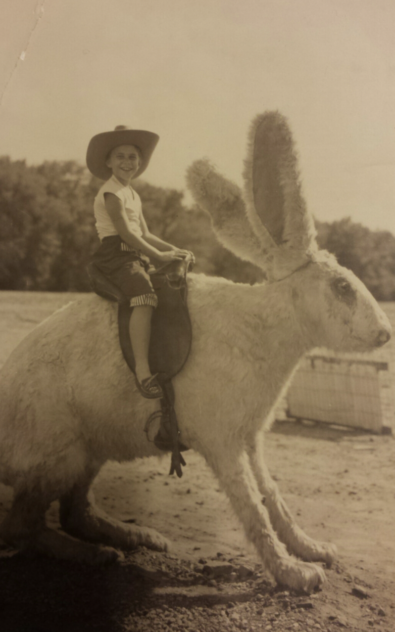 A little boy riding an odd giant rabbit, 1956.