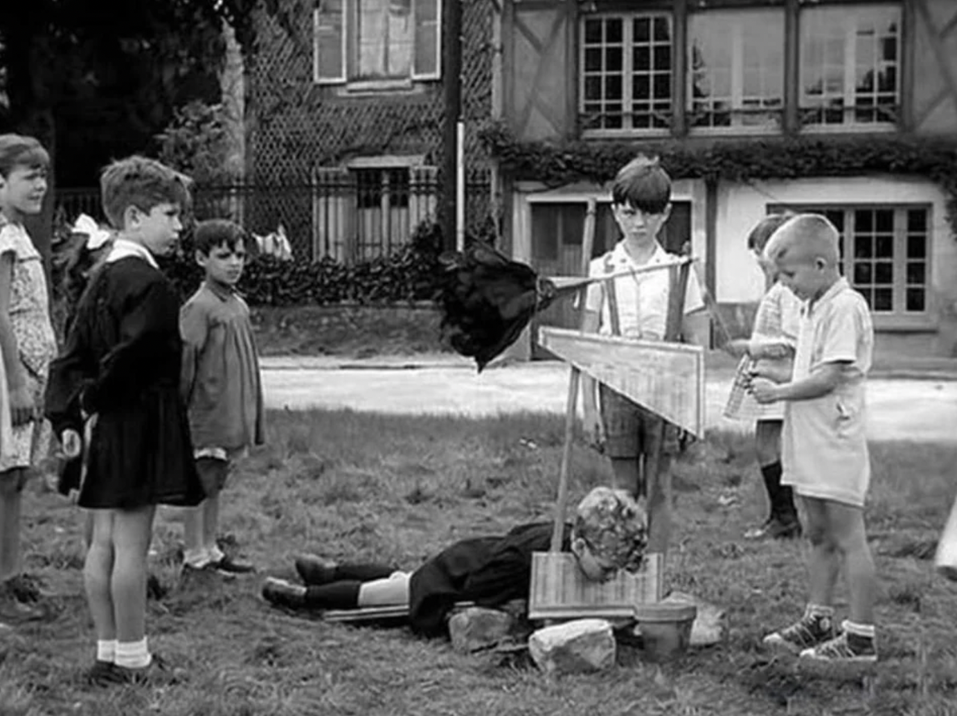 Children playing with a toy guillotine, France, 1959.