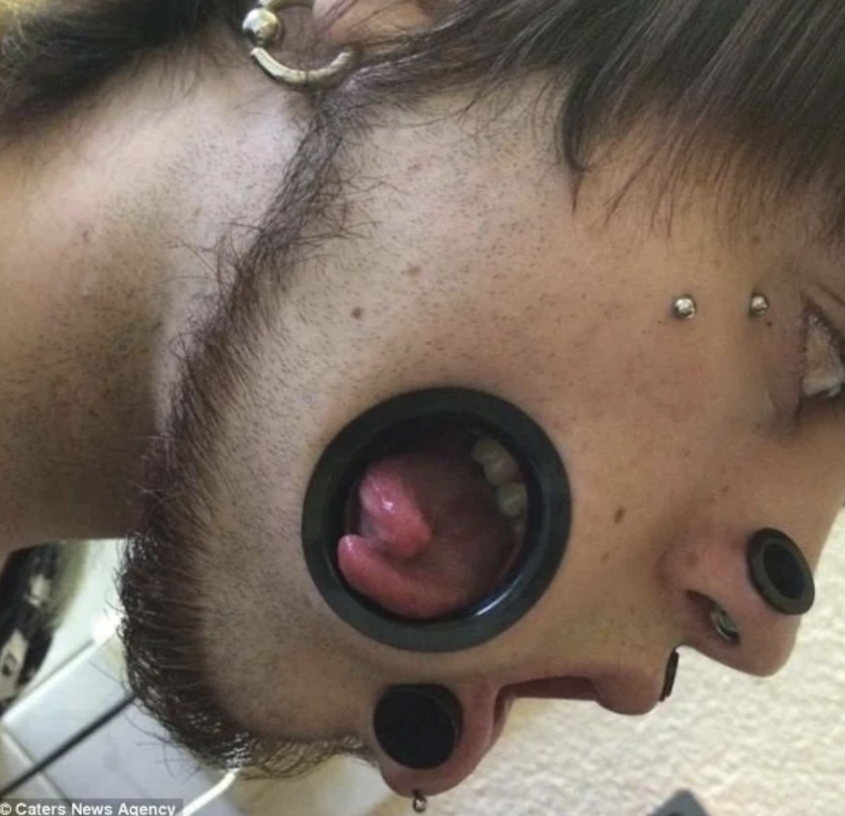 mouth cheek piercing - Caters News Agency