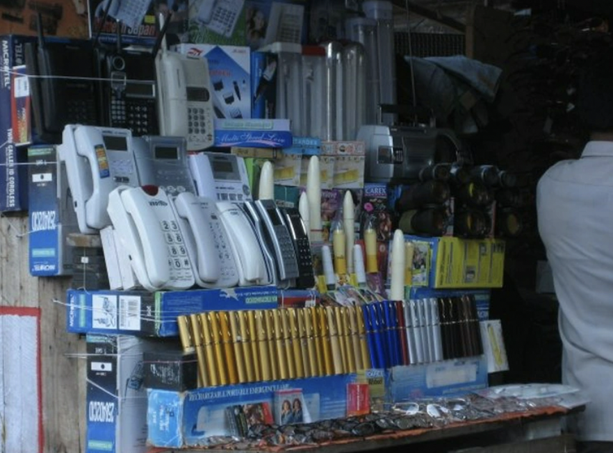 “Street vendor selling telephones, glasses and dildos at his stand.”