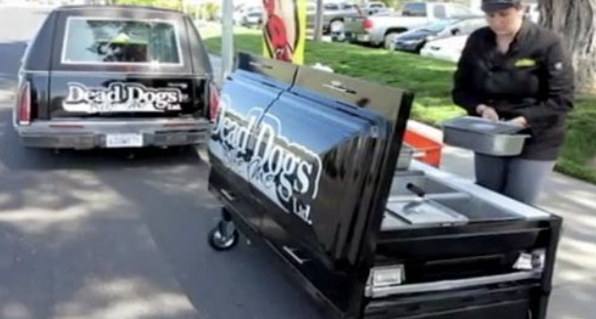 Vendor sells hot dogs out of a hearse. 