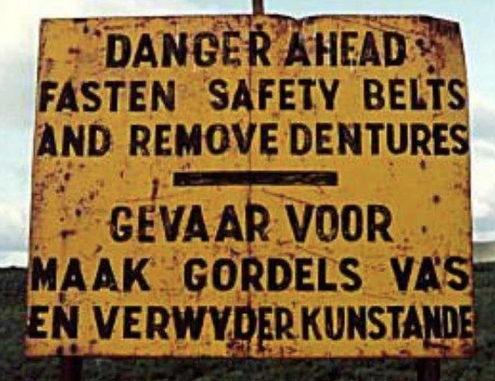 signage - Danger Ahead Fasten Safety Belts And Remove Dentures Gevaar Voor Maak Gordels Vas En Verwyder Kunstande