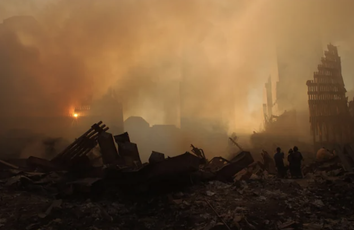 The sun streams through the dust and smoke over the wreckage of the World Trade Center, as search and rescue efforts continue at ground zero. 13, September, 2001.