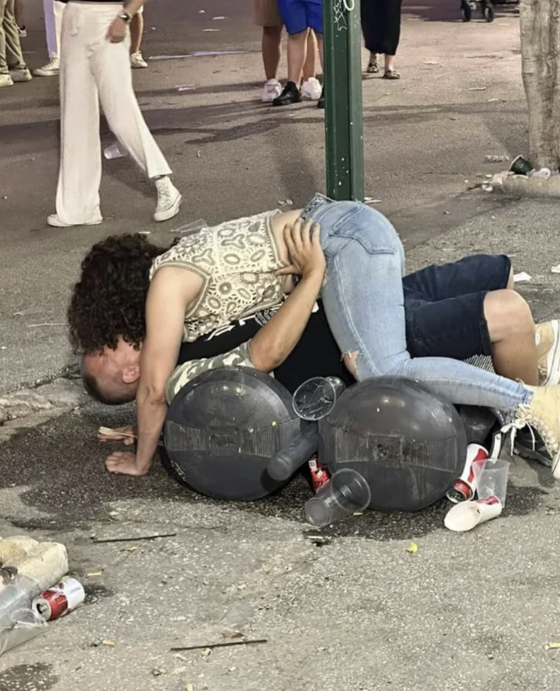 “At a fair I came across two people kissing on top of trash bins. Looks like a rubbish kiss anyway.”