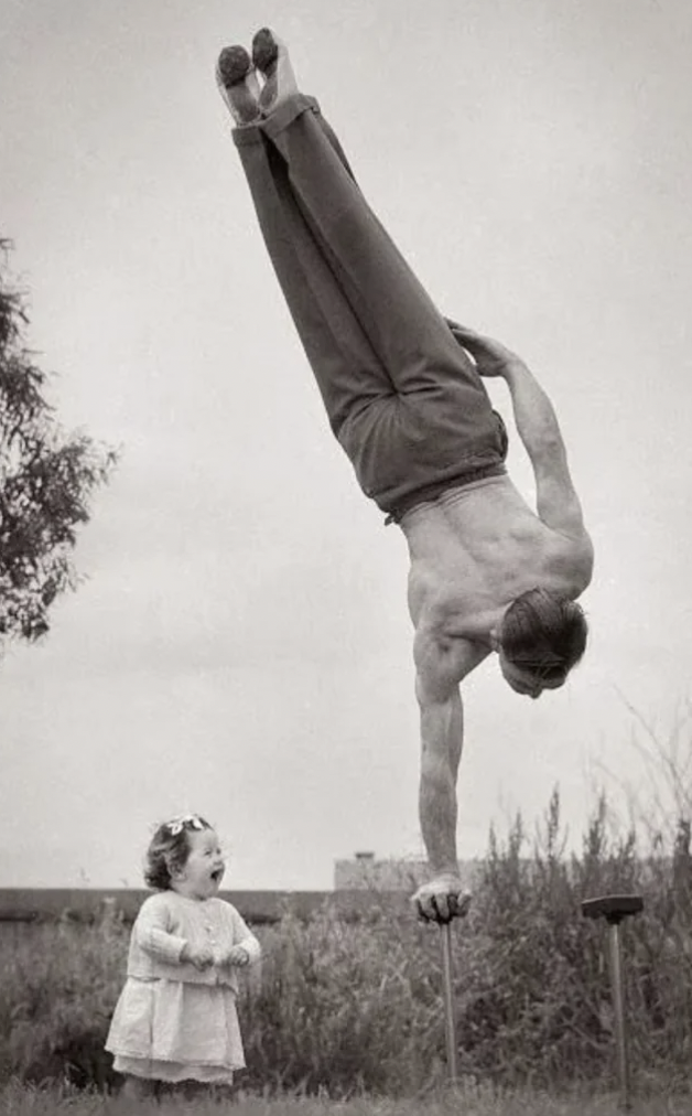 father and baby daughter handstand 1940s