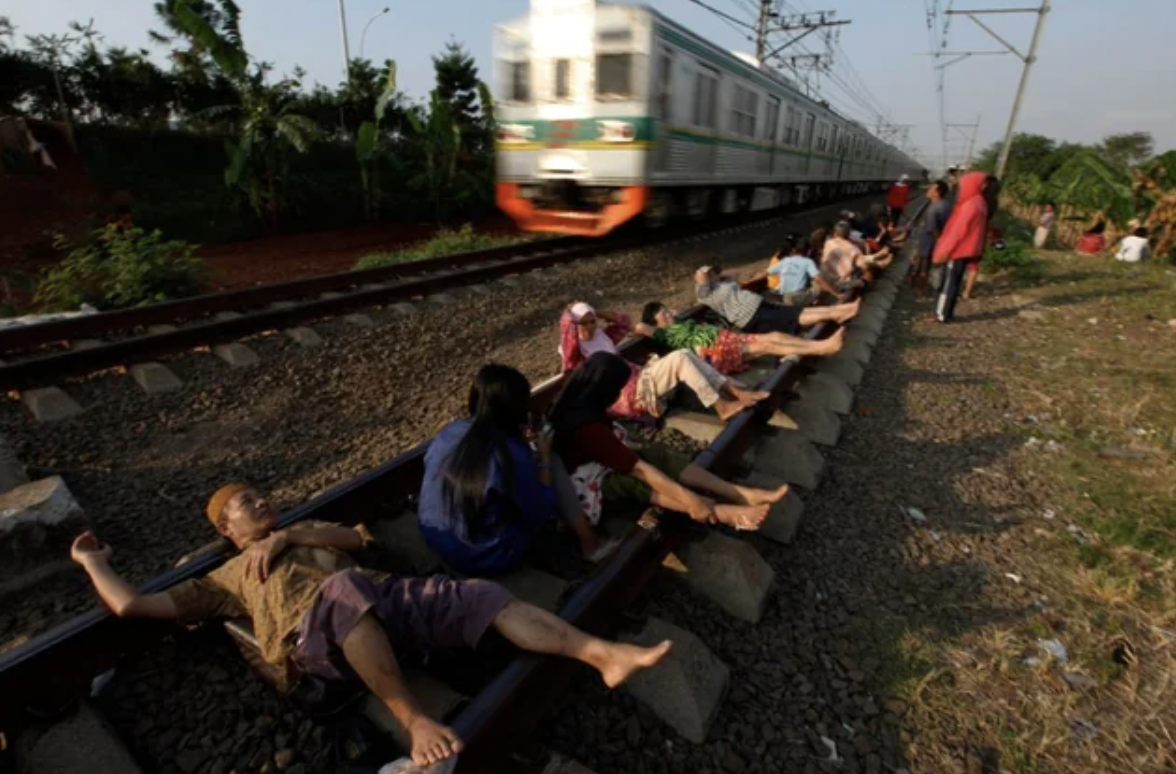 people lying on train tracks