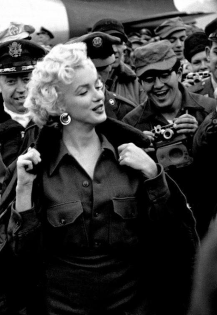 Happy solider takes a photo of Marilyn Monroe.