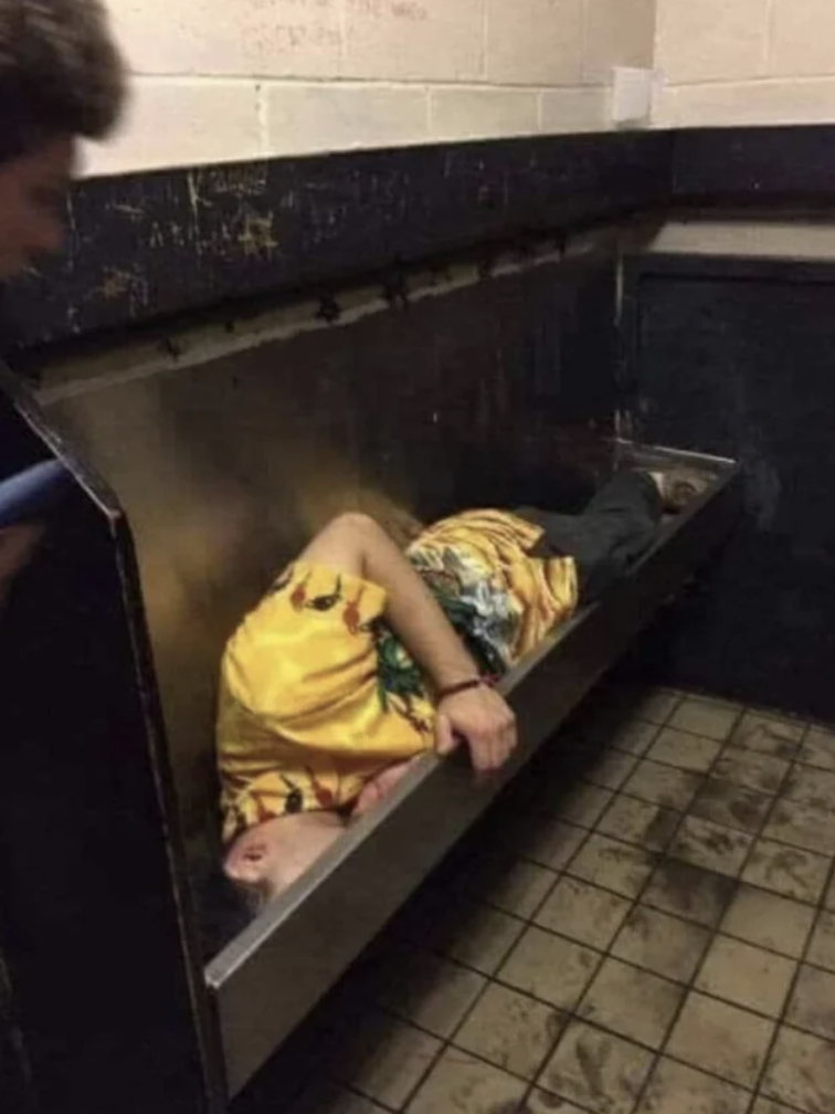 man asleep in urinal