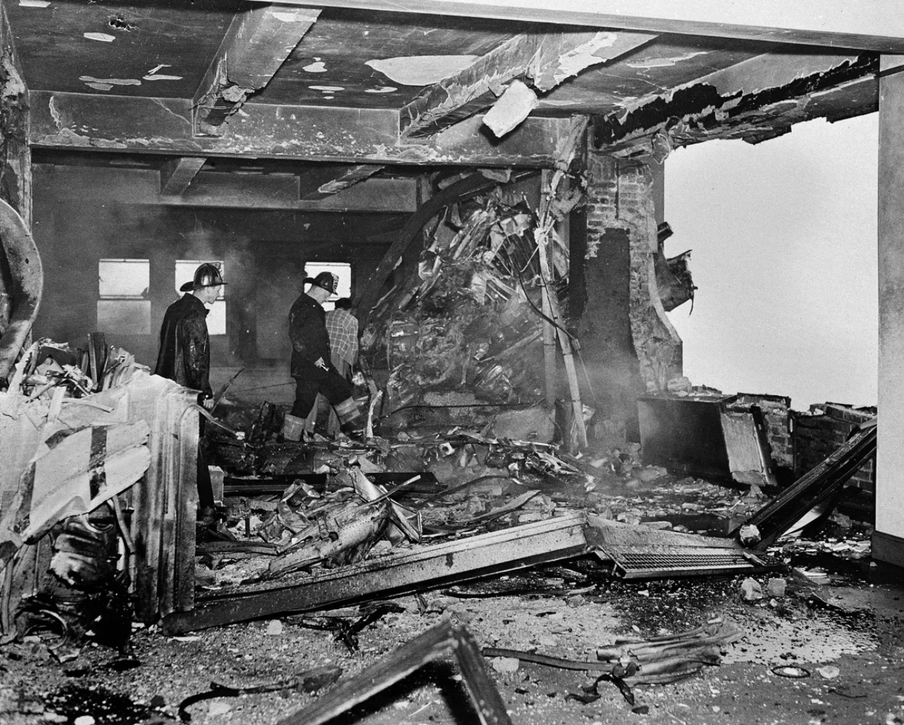 Firemen search through the charred ruins.