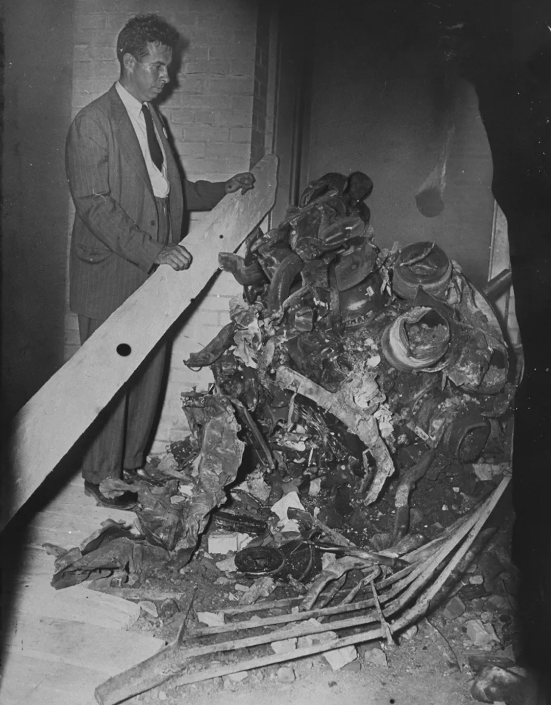 A man standing with one of the bomber’s motors. 