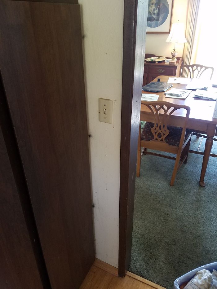 Black spots on the wall from years of opening and closing these cabinet doors.