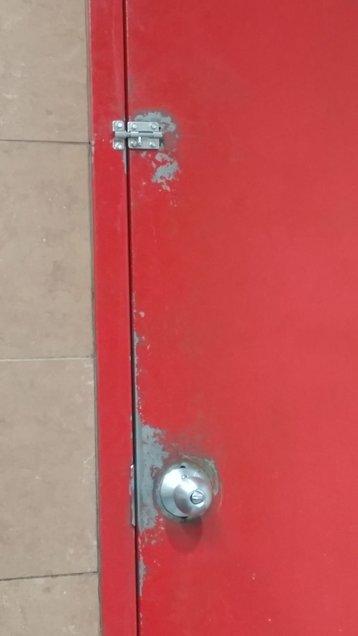 The paint on this bathroom door at the mechanics shop has been eaten away by the oils and chemicals on the mechanic's hands over the year.