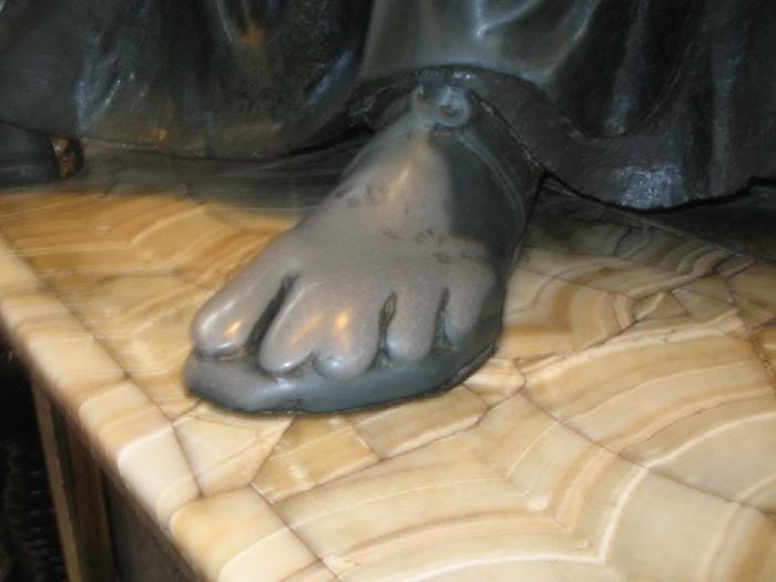 Years of people touching the foot on this statue have resulted in the foot looking like  it belongs to a Simpsons character.