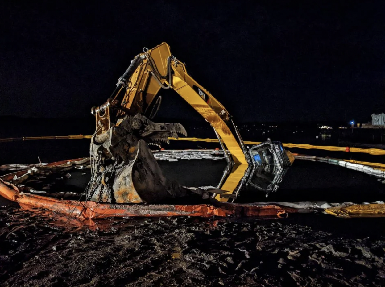 Excavator sank in the mud during a rising tide in Hingham Harbor, Massachusetts.