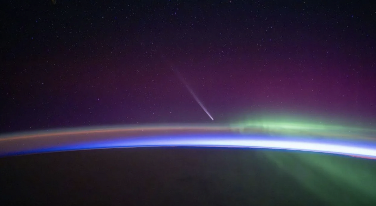 “Comet rises up over the horizon just before orbital sunrise with aurora streaking by.” From astronaut Matthew Dominick.