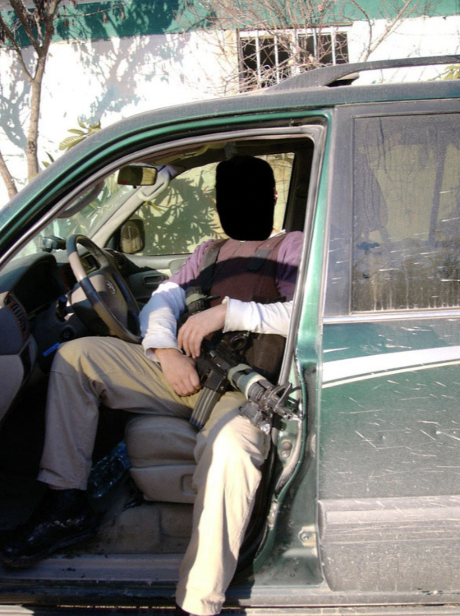 A British SAS soldier, undercover in civilian clothing, poses for a photo behind the wheel of a SUV in Iraq.