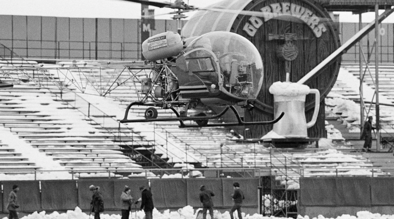 The Milwaukee Brewers use a helicopter to clear snow off of the field in 1972.