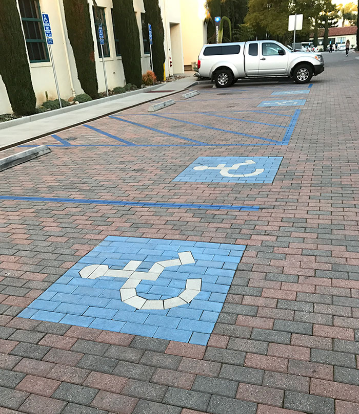 This campus uses blue and white colored bricks / pavers for handicapped parking spots, instead of just painting the asphalt.