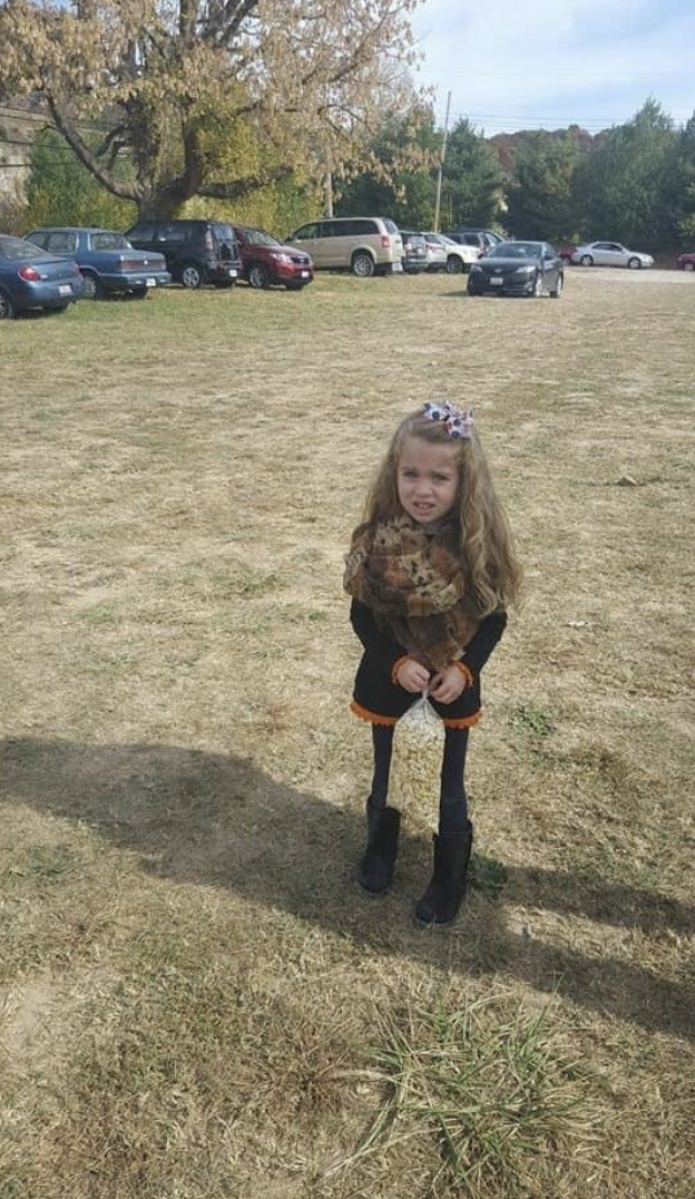 little girl holding popcorn