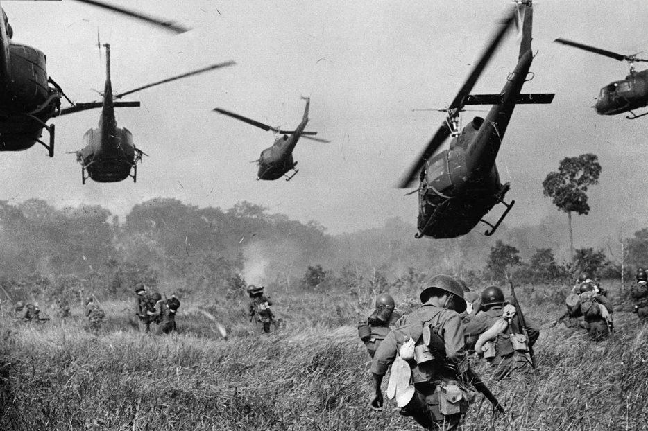 U.S. helicopters pour machine-gun fire into the tree line to cover the advance of South Vietnamese troops, 1965.