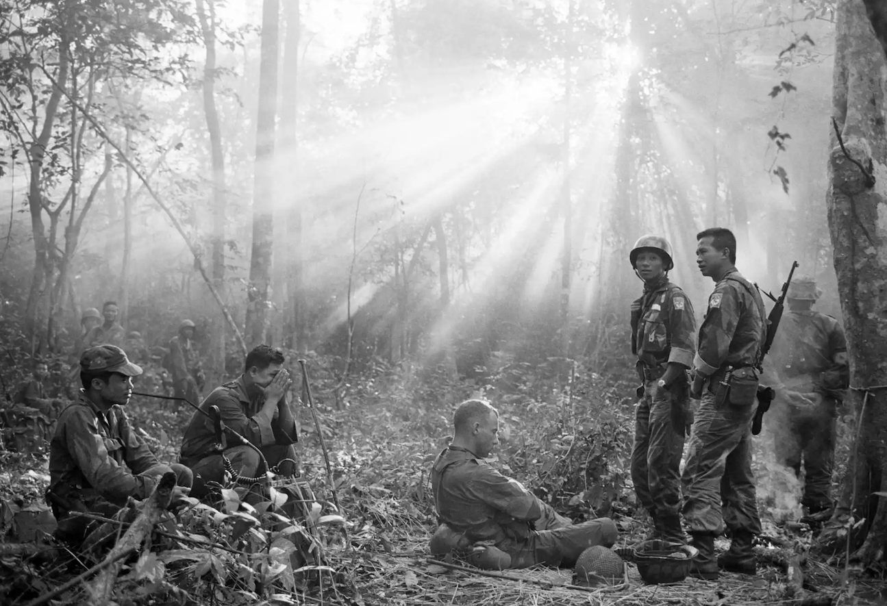 South Vietnamese troops, joined by US advisers, rest after a tense night of waiting in an ambush position for a Vietcong attack that did not come, January 1965.