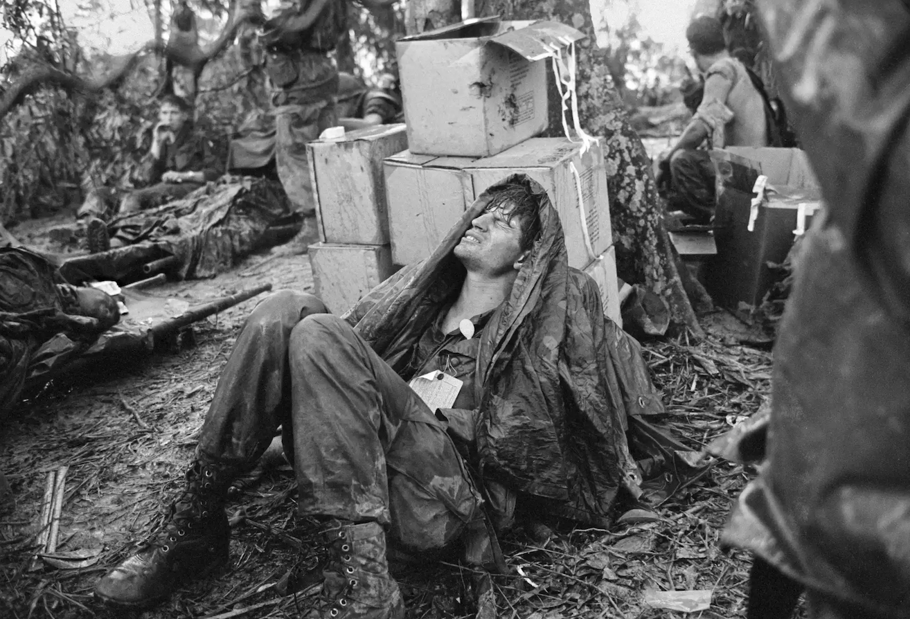 A US paratrooper, wounded in the battle for Hamburger Hill, grimaces in pain as he awaits medical evacuation at base camp near the Laotian border on 19 May 1969.